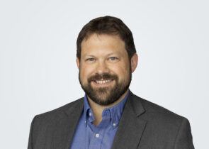 Headshot of Luke Werner, a man with brown hair, in front of a light grey background.