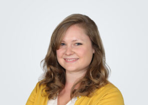 Headshot of Margaret Wild, a woman with brown hair, in front of a light grey background.