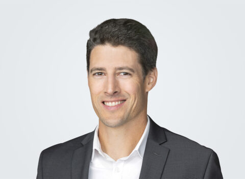 Headshot of Michael Humm, a person with short, dark brown hair, wearing a charcoal suit.