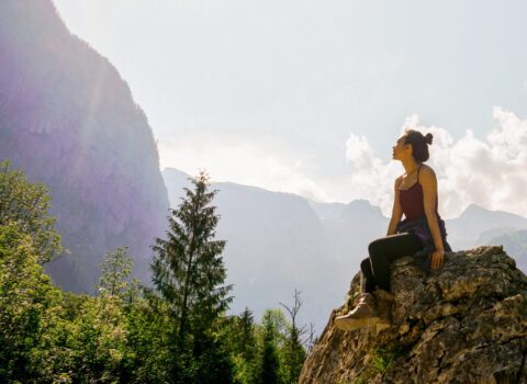 A woman on a mountain experiencing nature and improving mental health