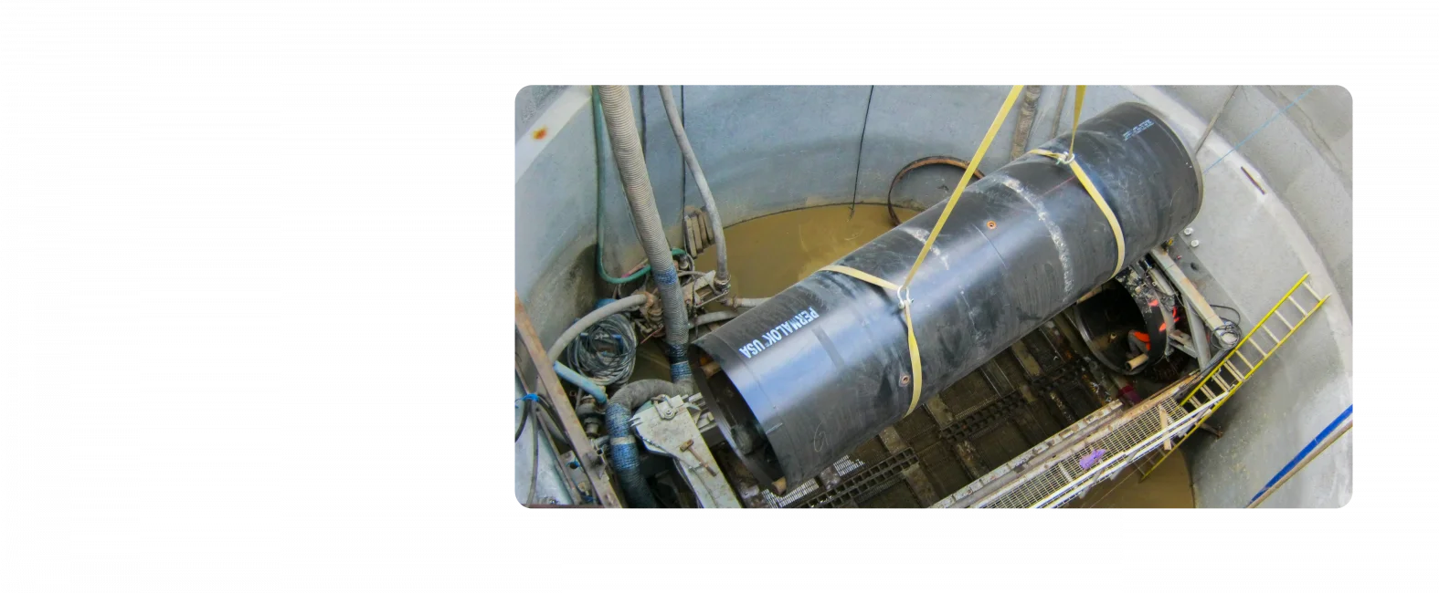 A pipeline installment. Photo is taken at ground level looking down into the ground.